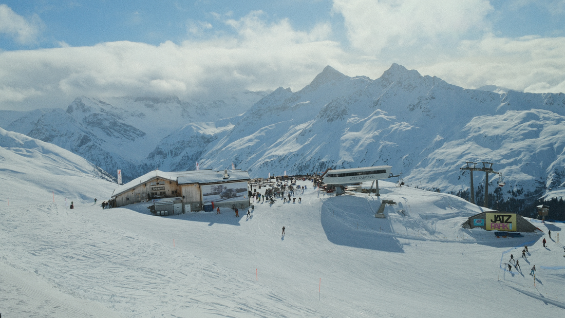 View of the Jatzhütte in Davos with stunning mountain scenery, showcasing the event location for HÖHENRAUSCH – a free mountain rave on March 16th